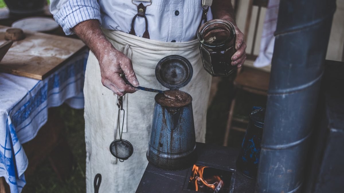 man brewing coffee on old stove