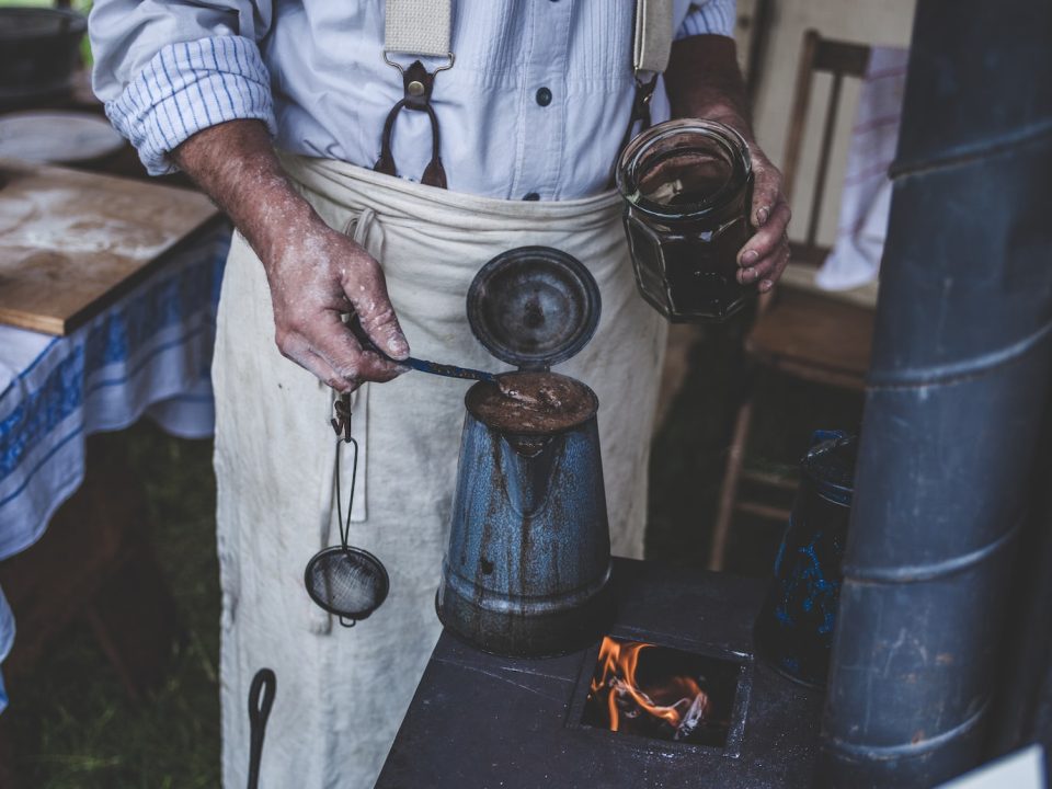 man brewing coffee on old stove